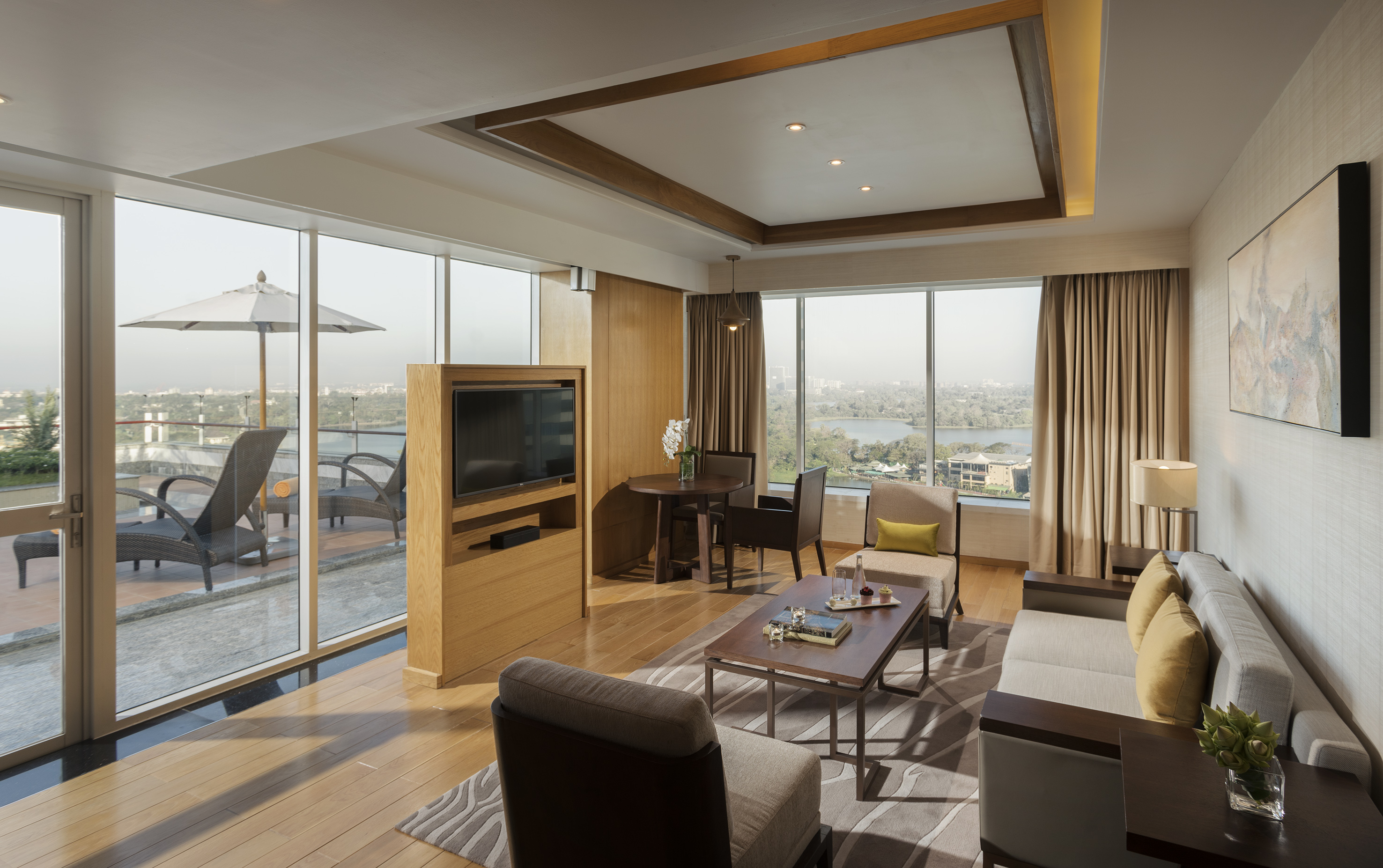 Modern hotel suite with lake view, private terrace, living room, and dining area.