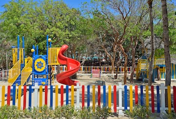 a playground with a slide and colorful fence