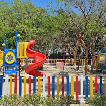 a playground with a slide and colorful fence