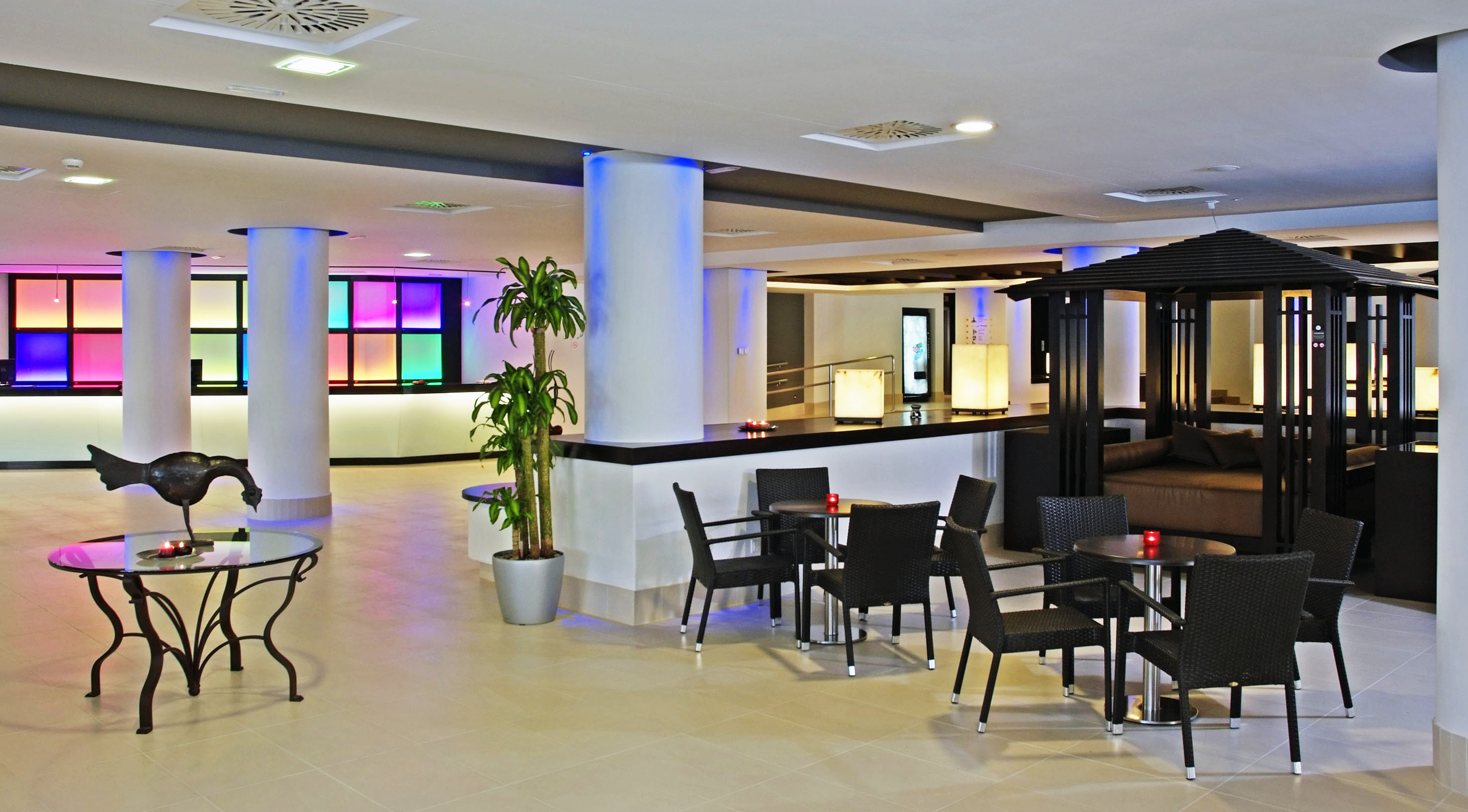 Vibrant hotel lounge, colorful reception, diverse seating, unique decor.