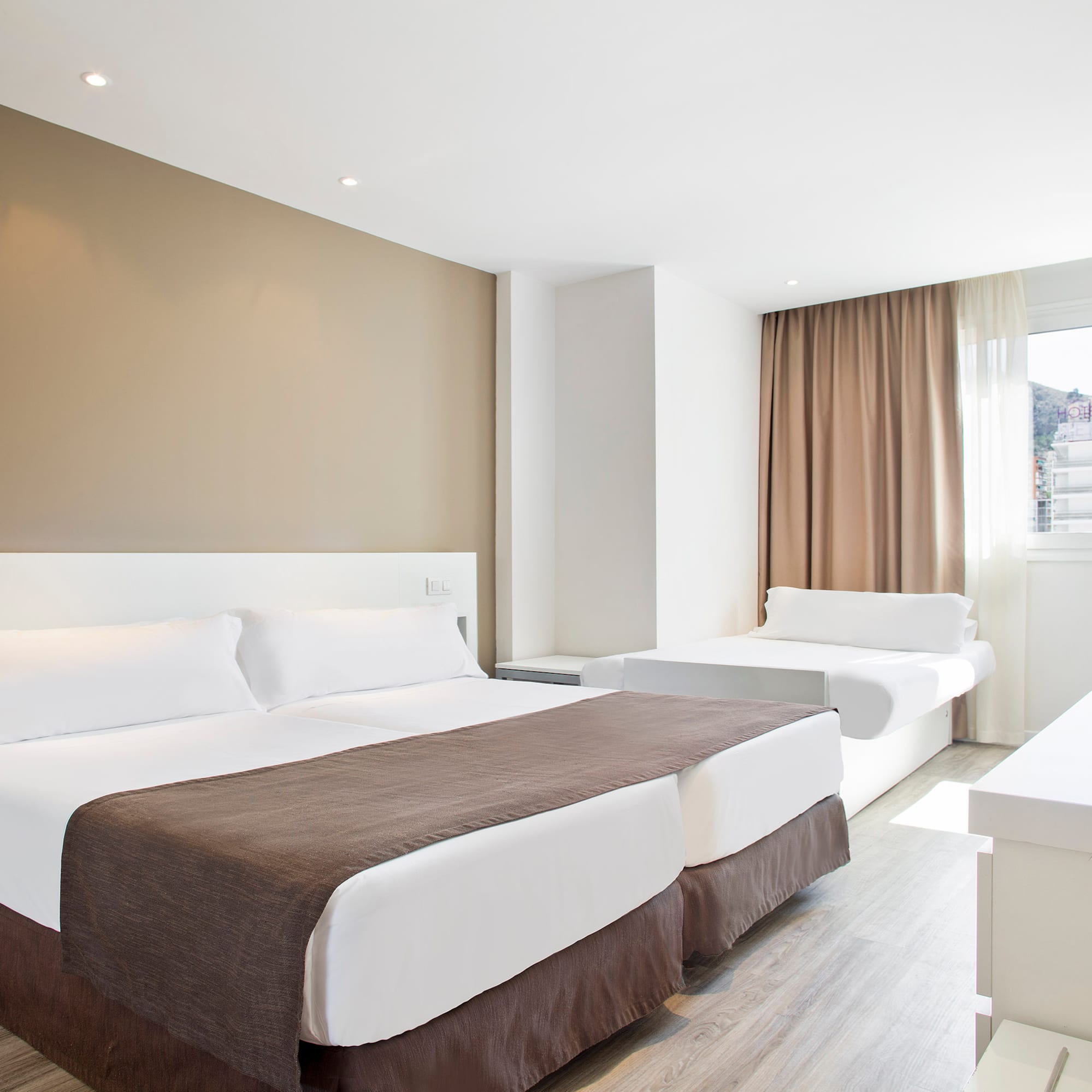 a room with two beds and a window