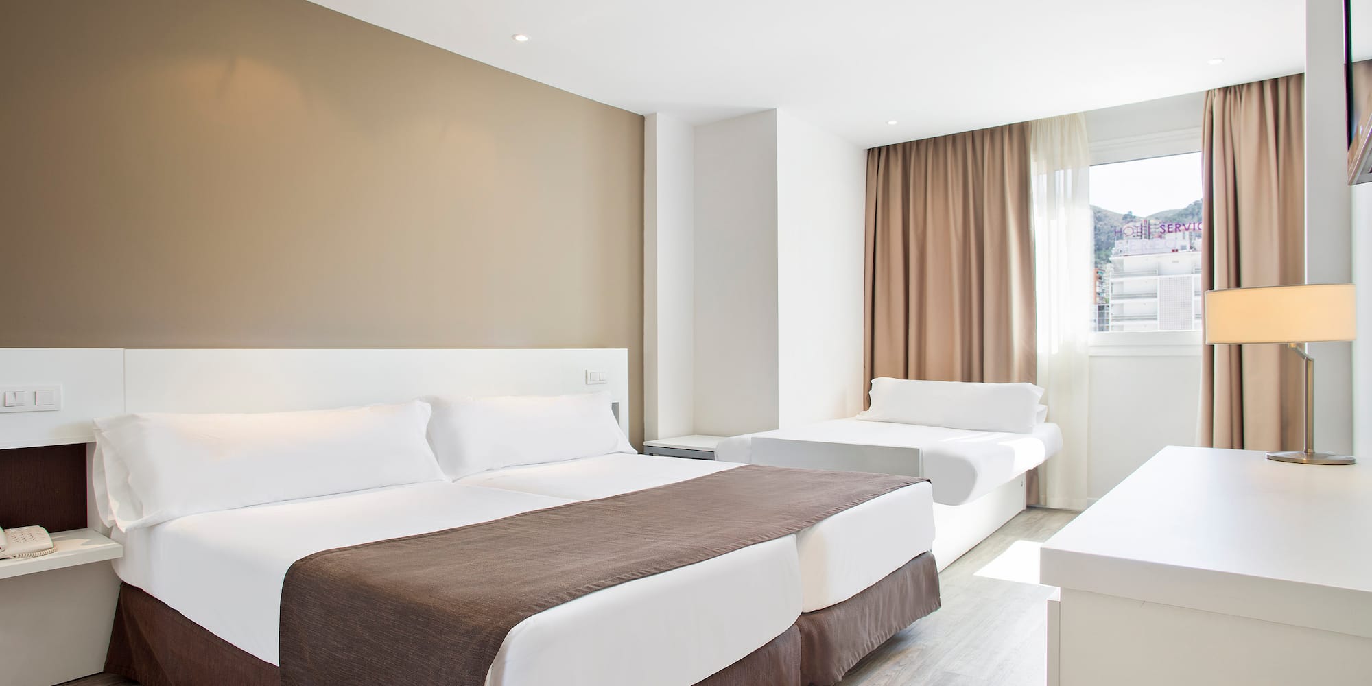 a room with two beds and a window