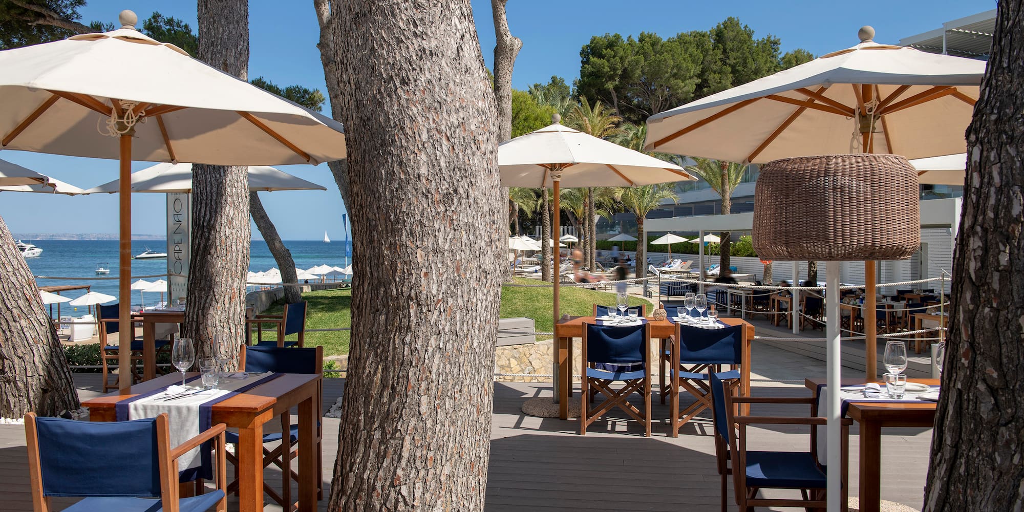 a tables and chairs outside with umbrellas