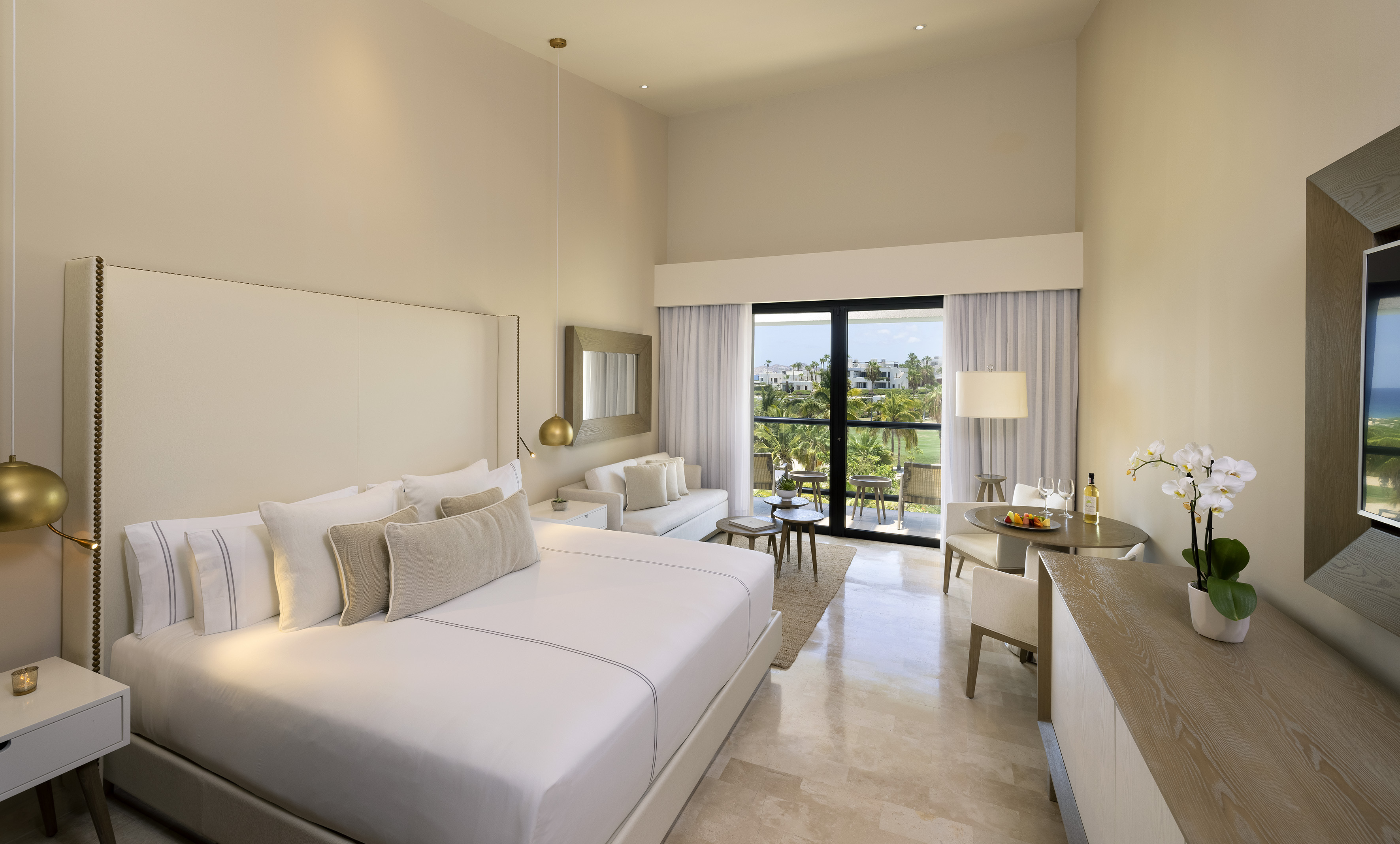 Modern luxury hotel room with king bed, private balcony, and golf course view.