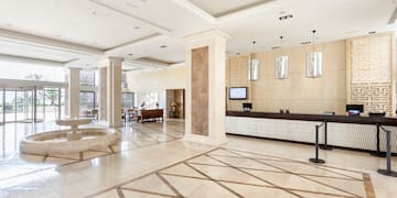 a large lobby with a reception desk and a fountain