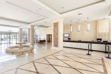 a large lobby with a reception desk and a fountain