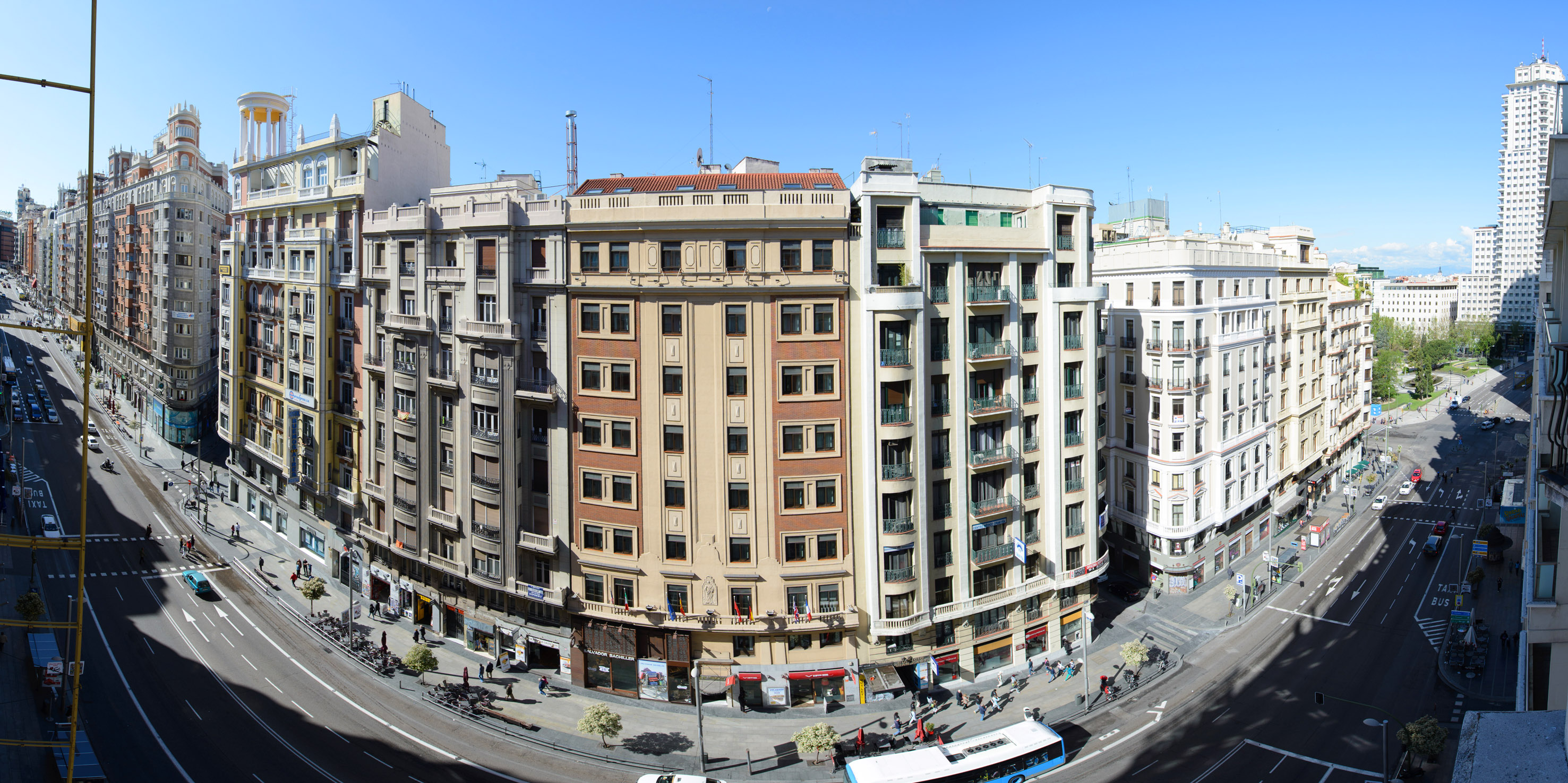 Panoramic view of a bustling Madrid street lined with classic multi-story buildings.
