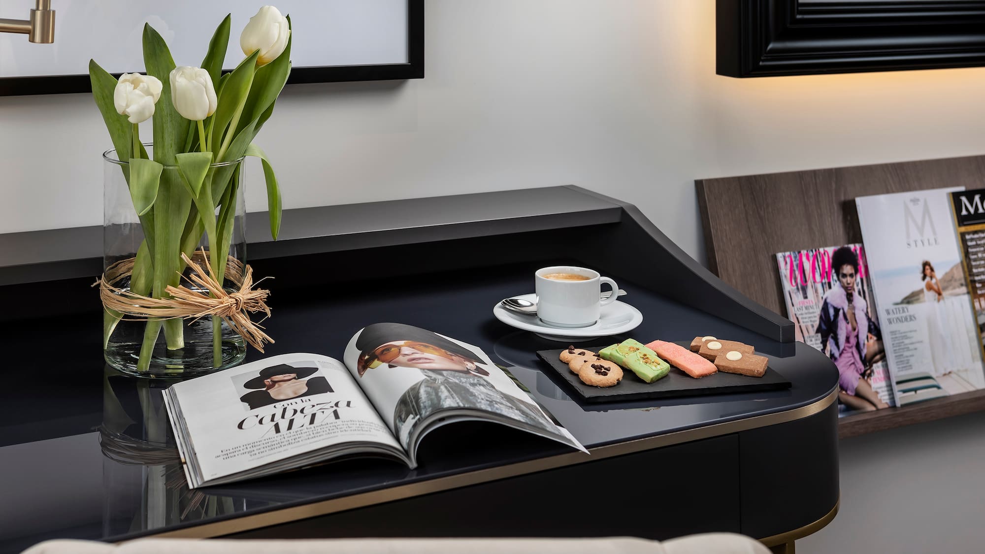 a coffee and cookies on a black table