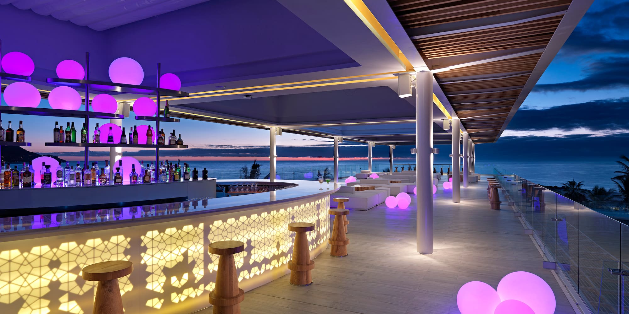 a bar with purple lights and a large body of water