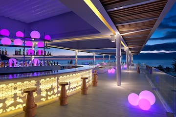 a bar with purple lights and a large body of water