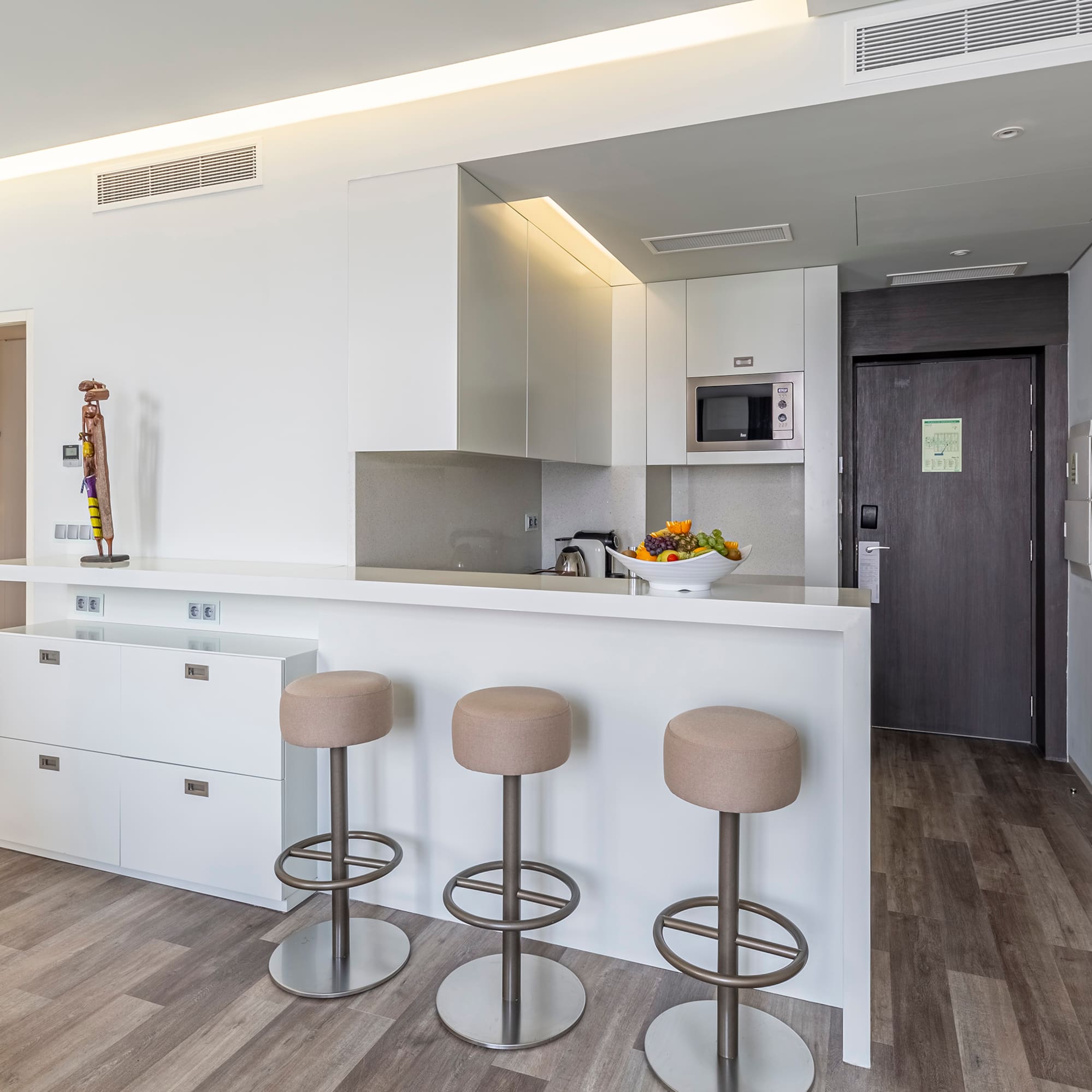 a kitchen with stools and a door