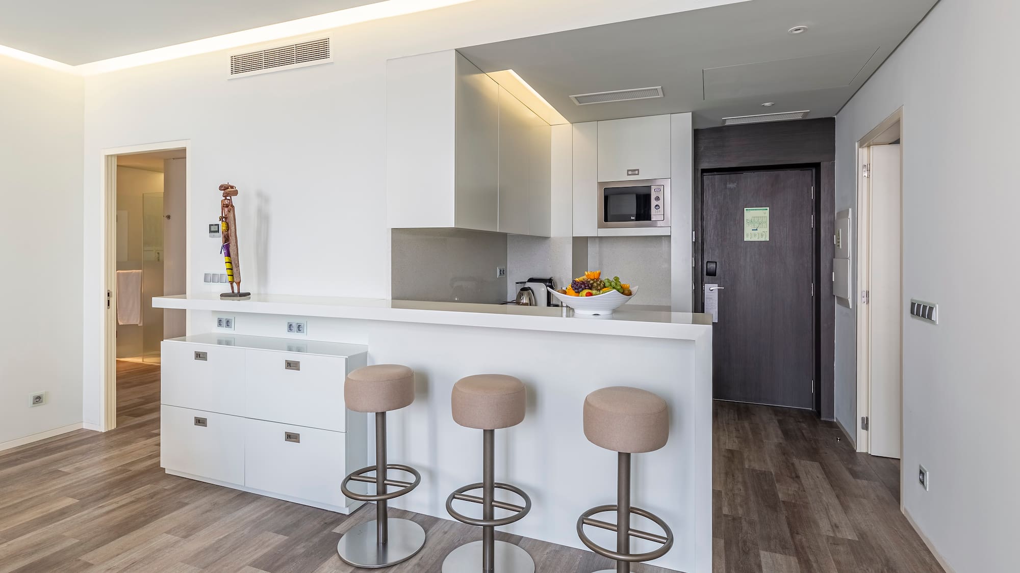a kitchen with stools and a door