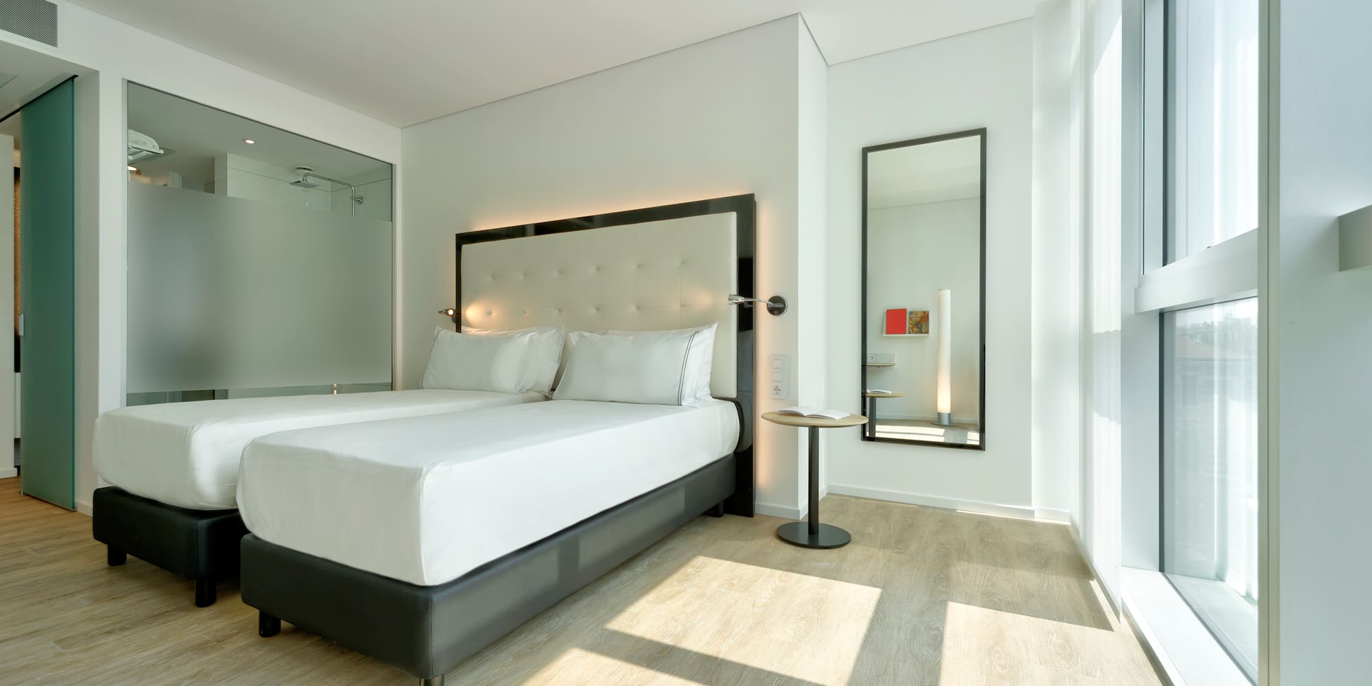 a room with two beds and a mirror