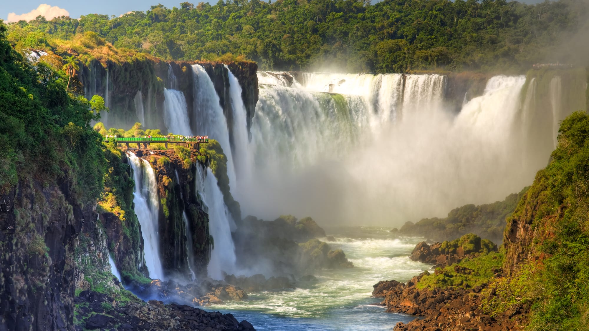 a large waterfall with trees around it