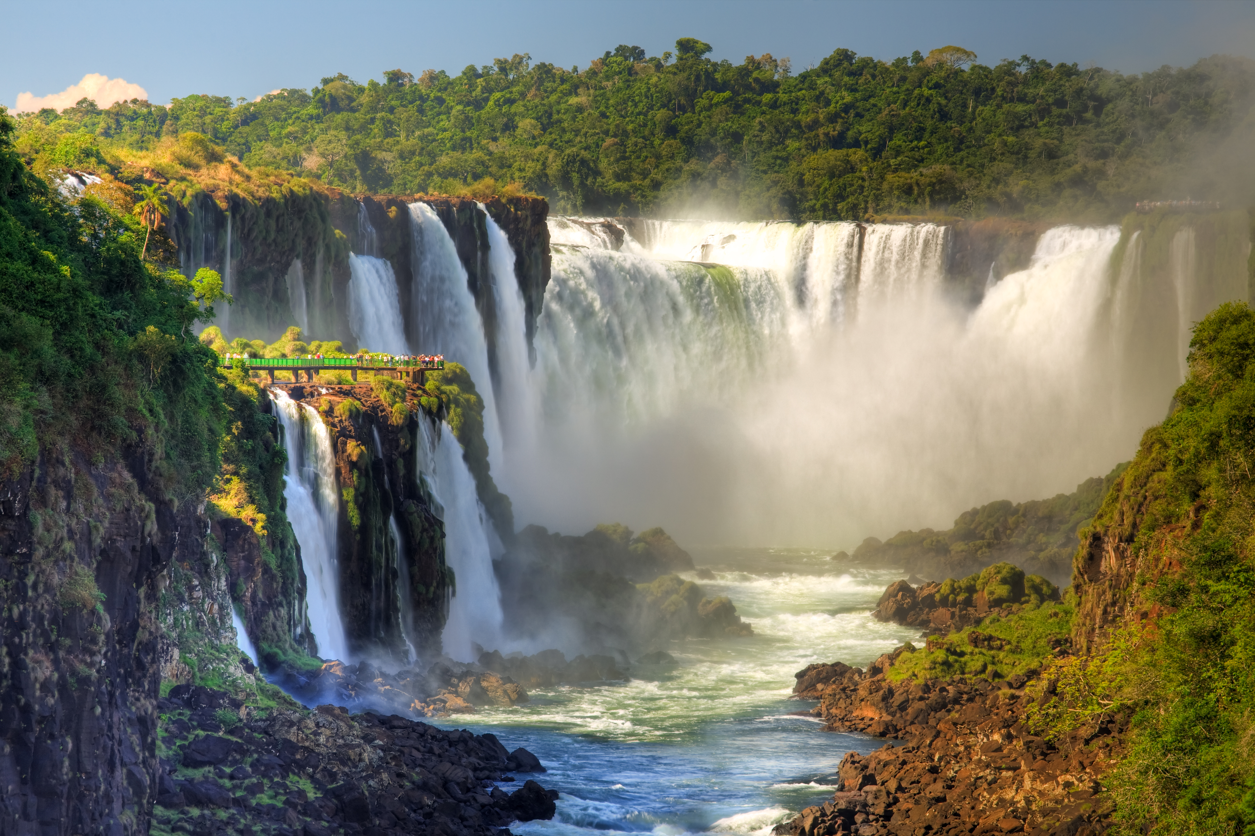 a large waterfall with trees around it