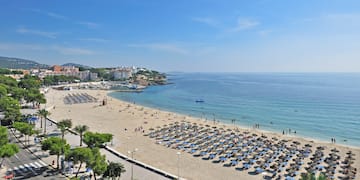 a beach with many umbrellas and people on it