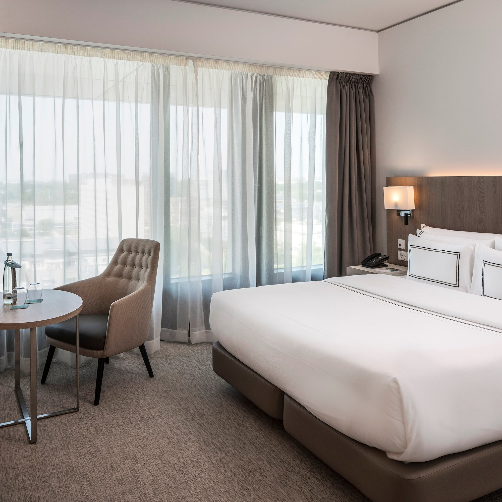 a hotel room with a bed and chair