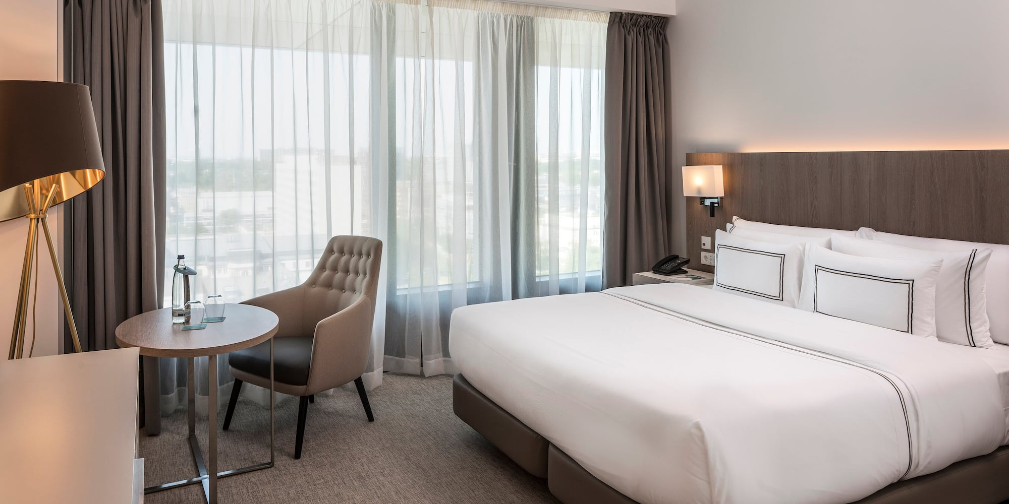 a hotel room with a bed and chair