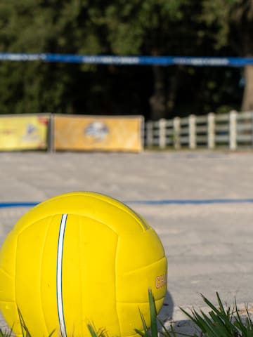 a yellow volleyball on a sandy field