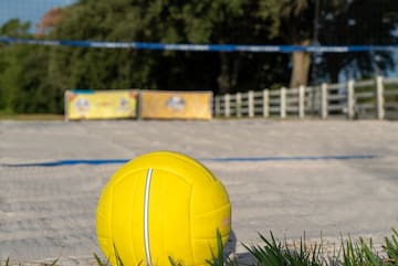 a yellow volleyball on a sandy field