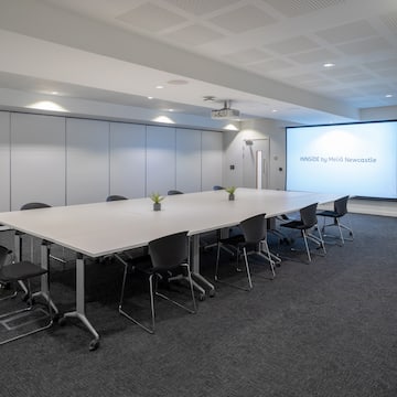 a large conference room with a projection screen