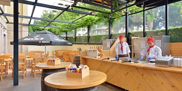 a group of men in white uniforms standing at a counter in a restaurant