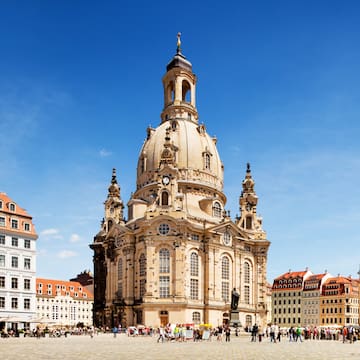 a large building with a dome and people in front with Dresden Frauenkirche in the background