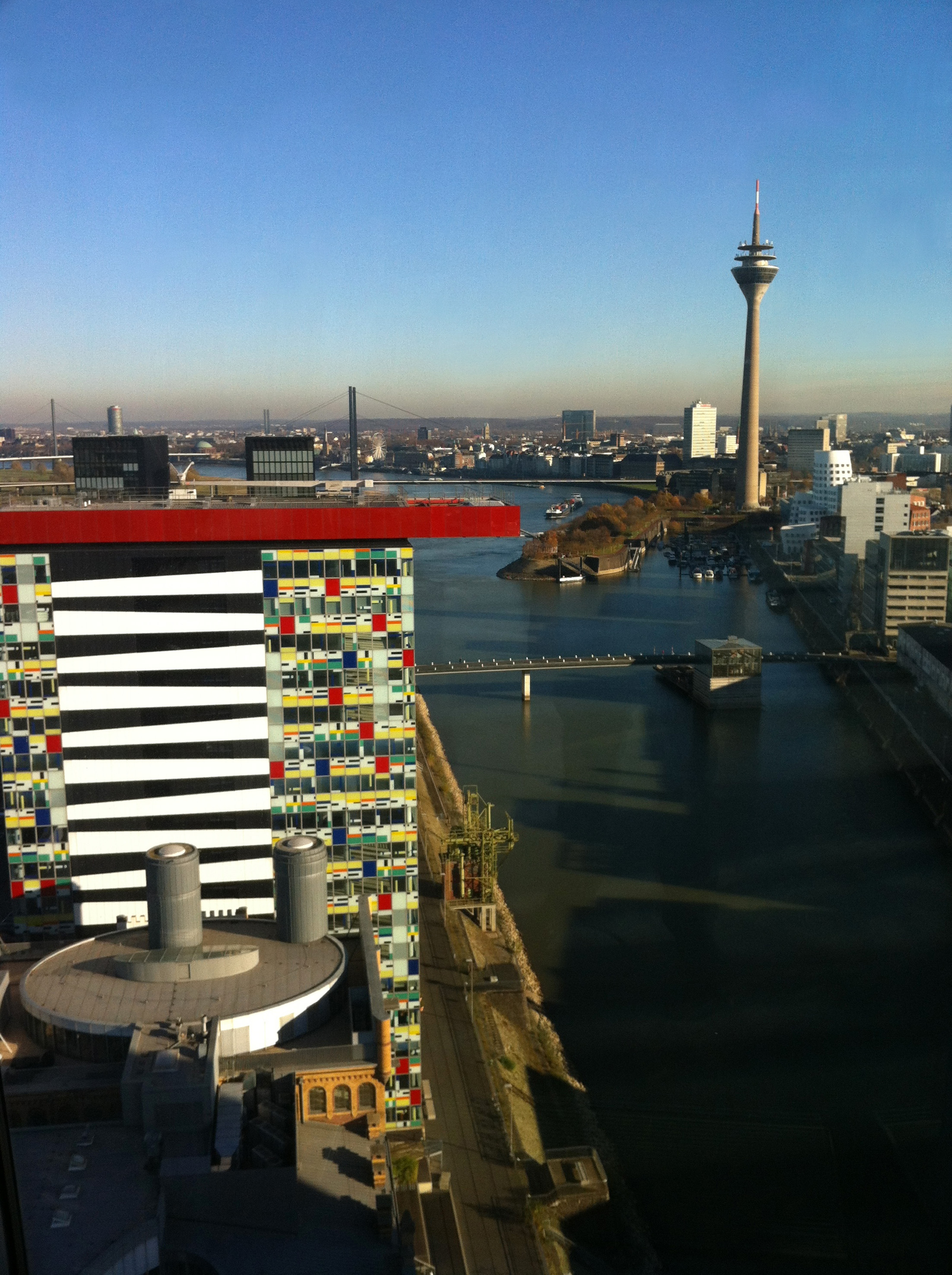 Düsseldorf cityscape with Rheinturm, modern colorful buildings, and Rhine harbor.