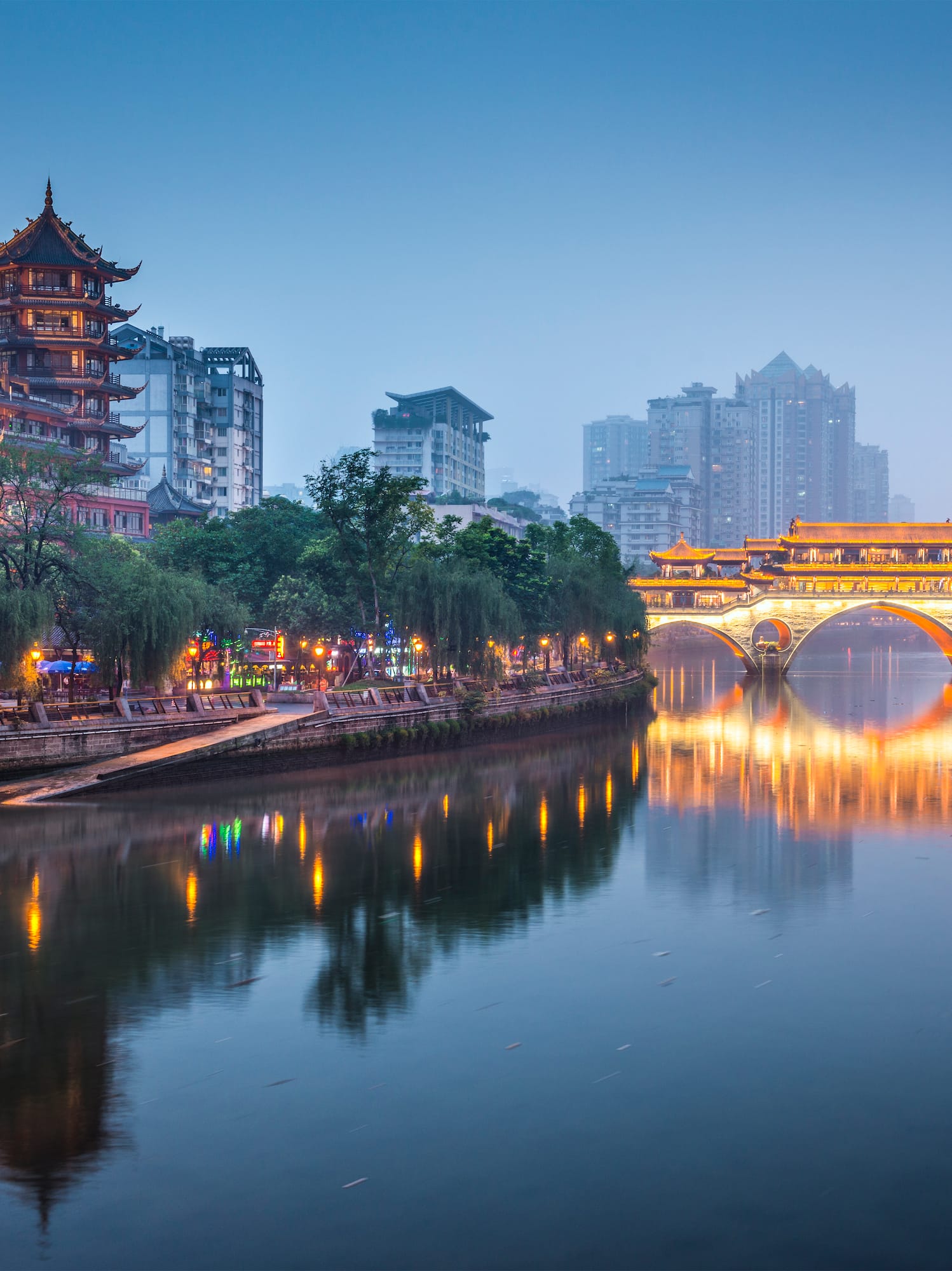 a bridge over a river with buildings in the background