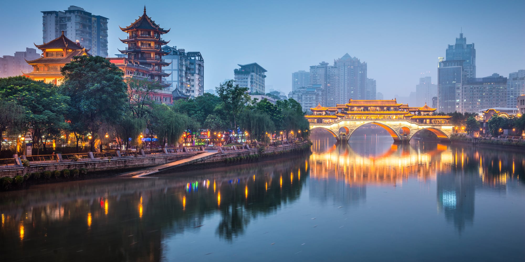 a bridge over a river with buildings in the background