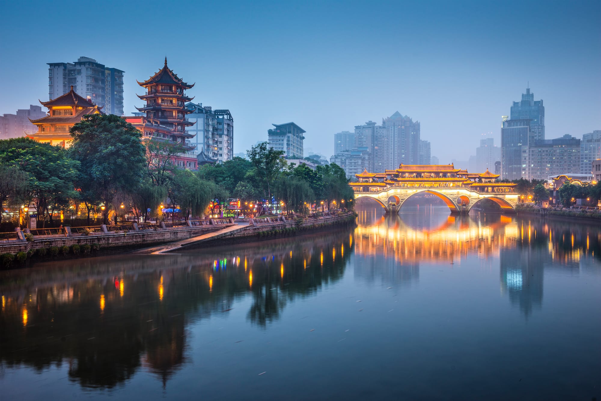 a bridge over a river with buildings in the background