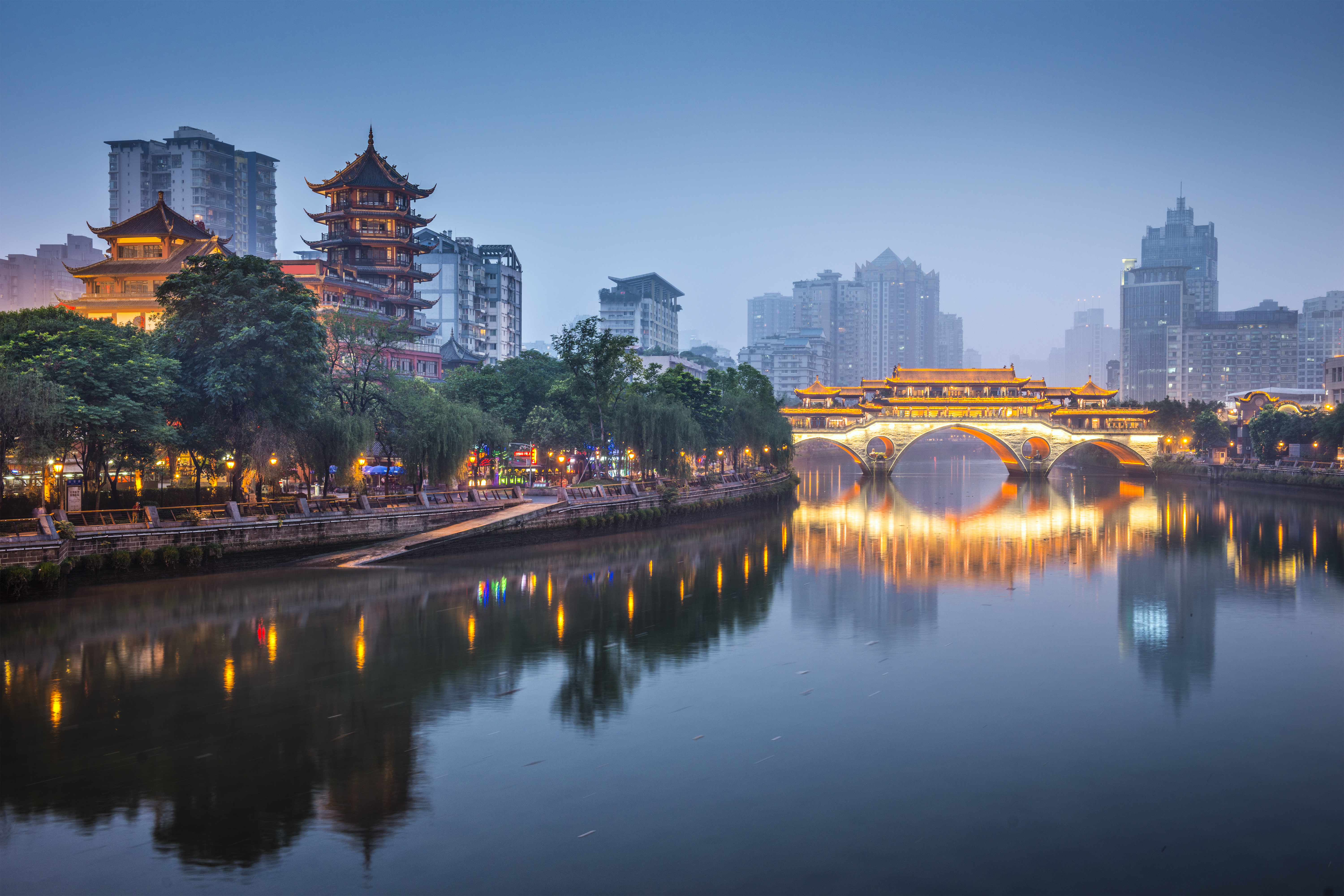 a bridge over a river with buildings in the background