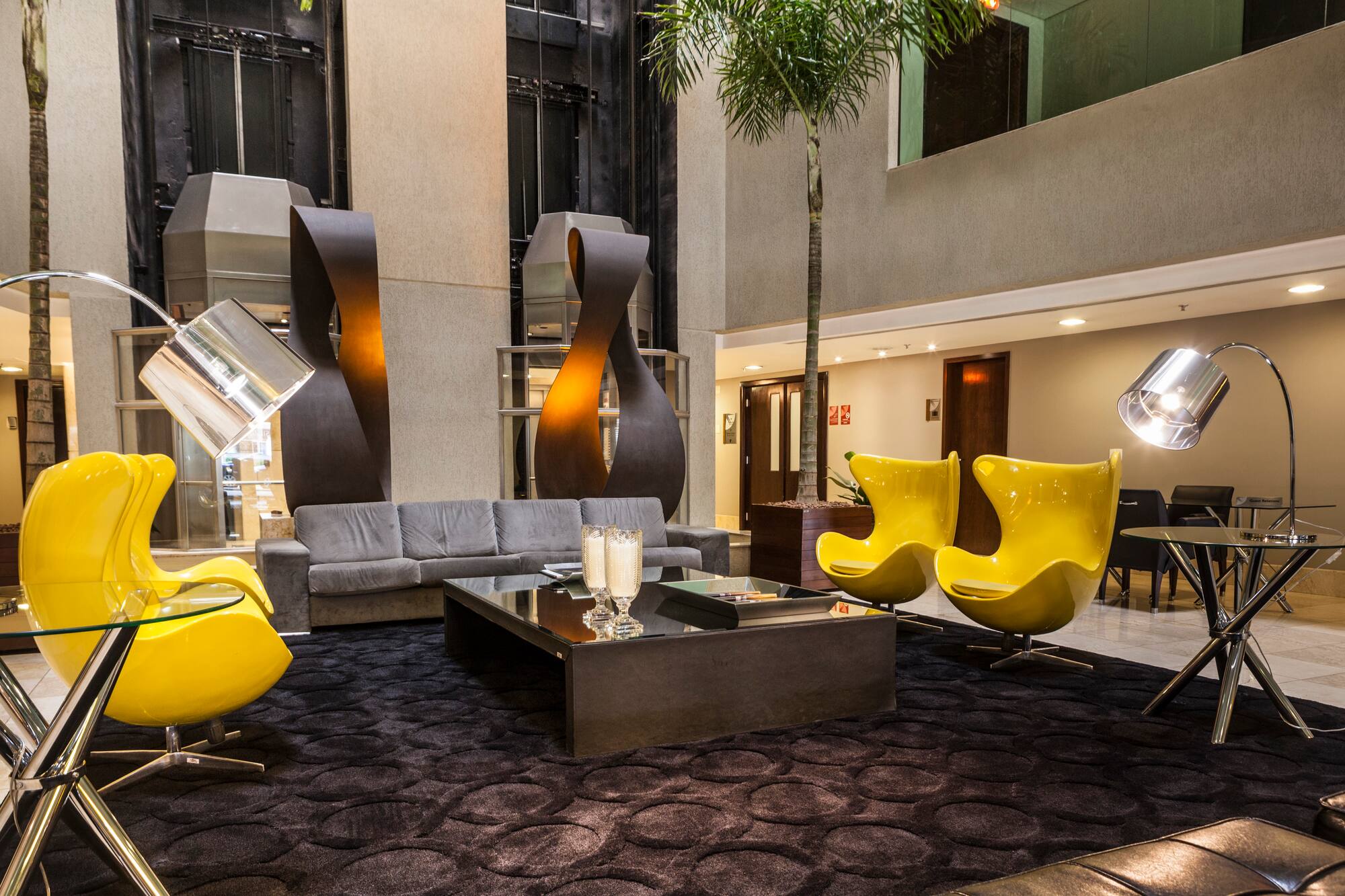 a room with a couch and yellow chairs