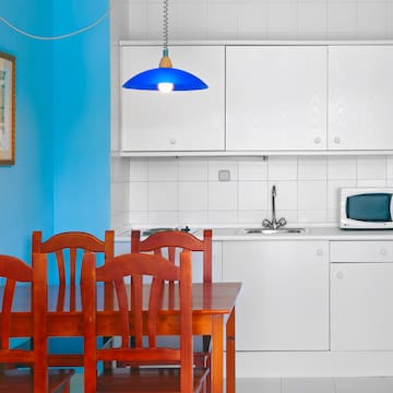 a kitchen with white cabinets and a table and chairs