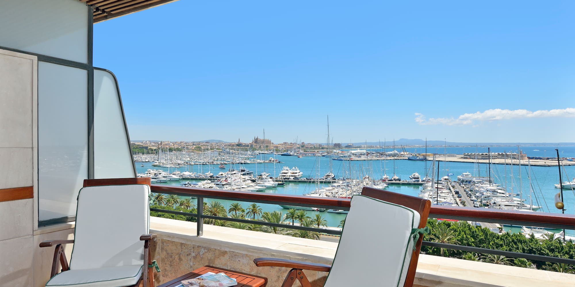 a deck with chairs and a table overlooking a marina