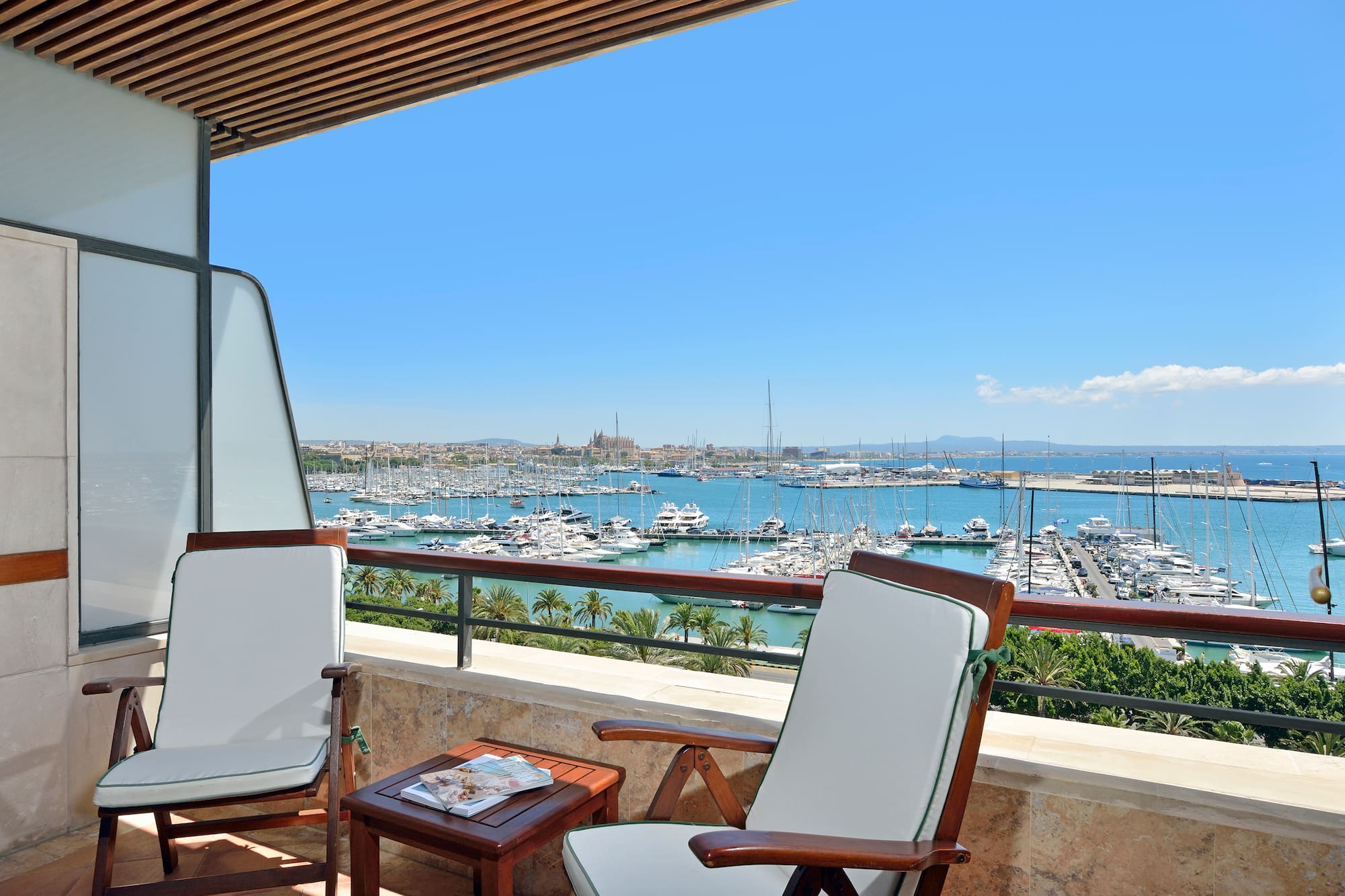 a deck with chairs and a table overlooking a marina