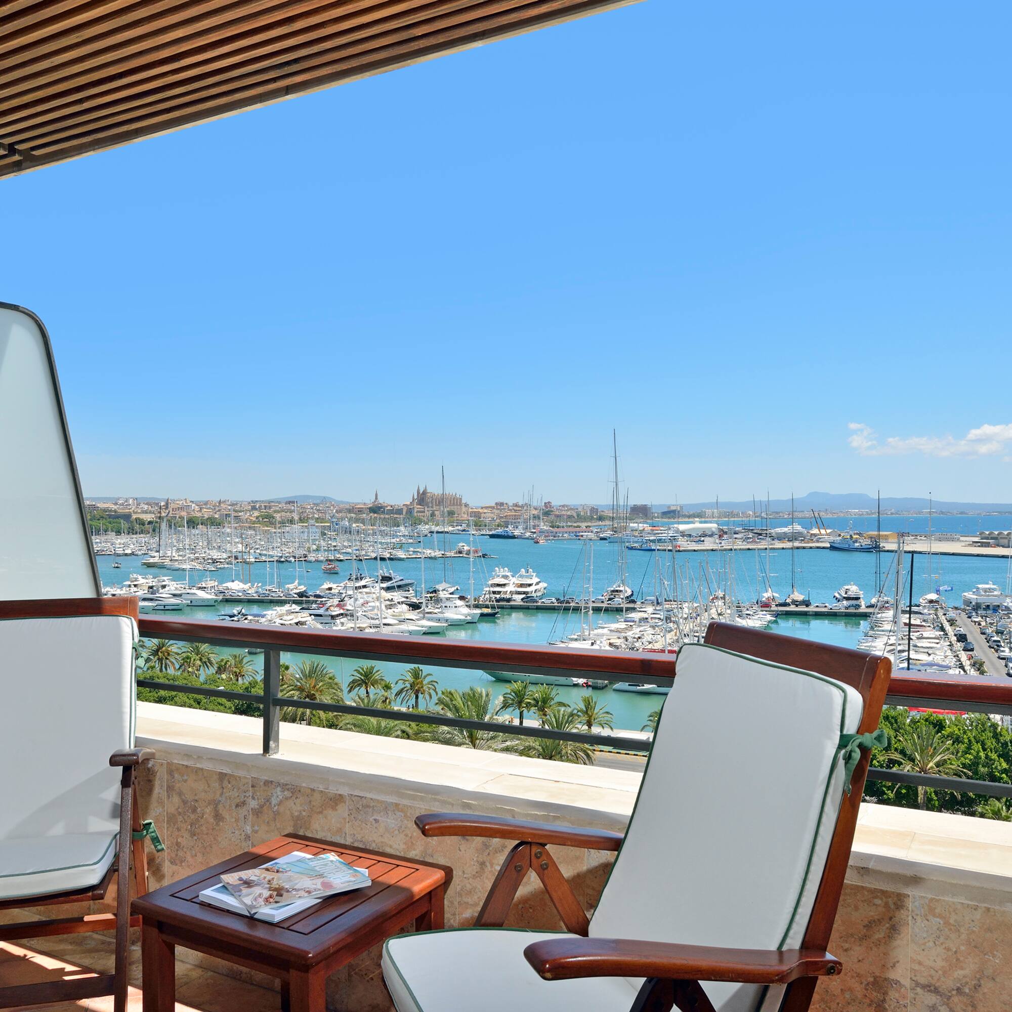 a deck with chairs and a table overlooking a marina