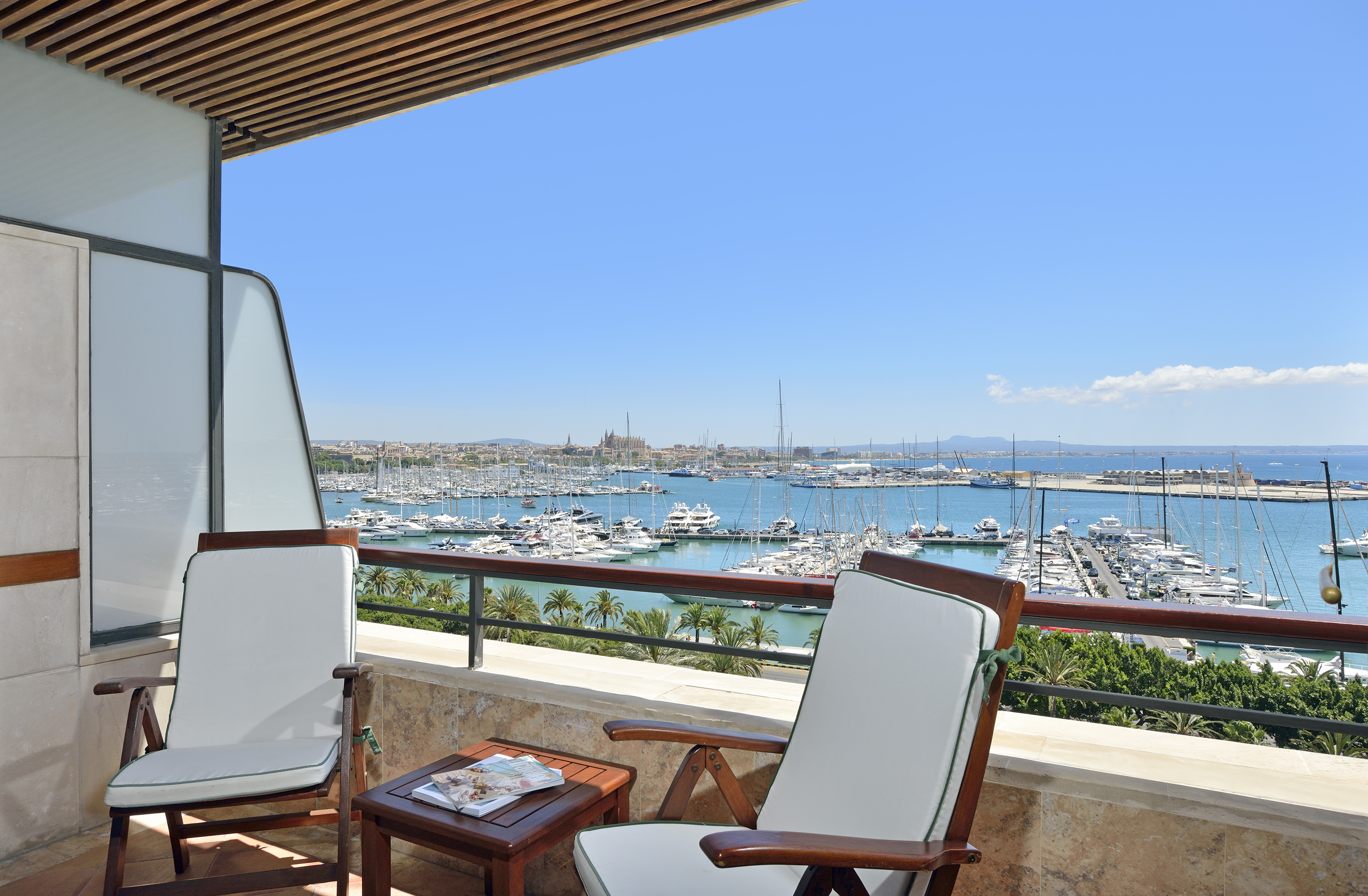Balcony with chairs overlooking Palma de Mallorca marina and cathedral.