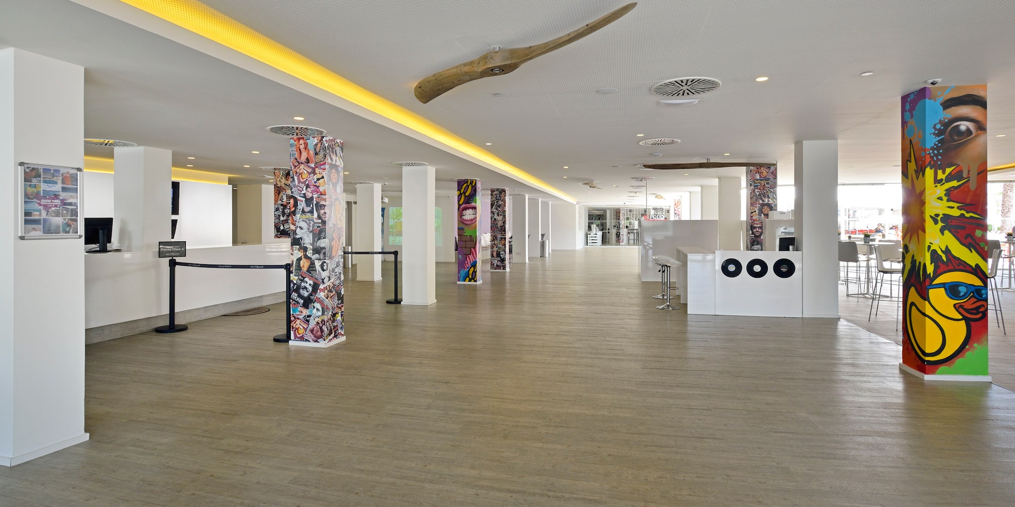 a large room with white columns and art on the walls
