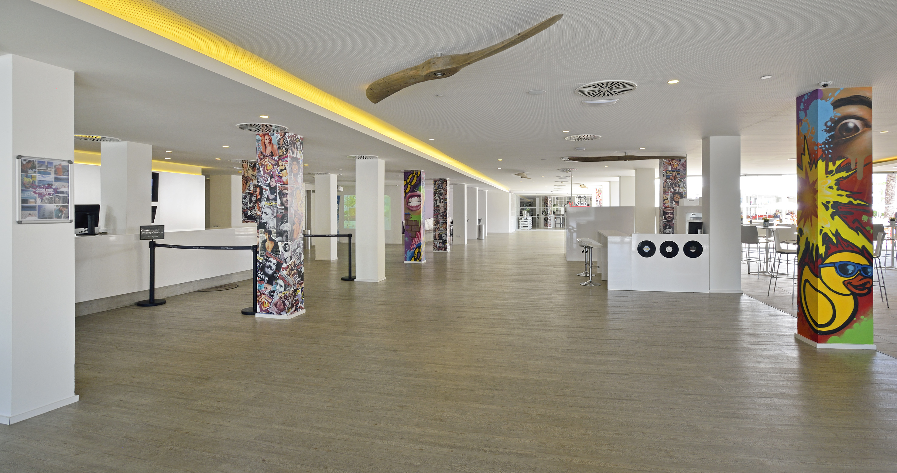 a large room with white columns and art on the walls