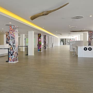 a large room with white columns and art on the walls