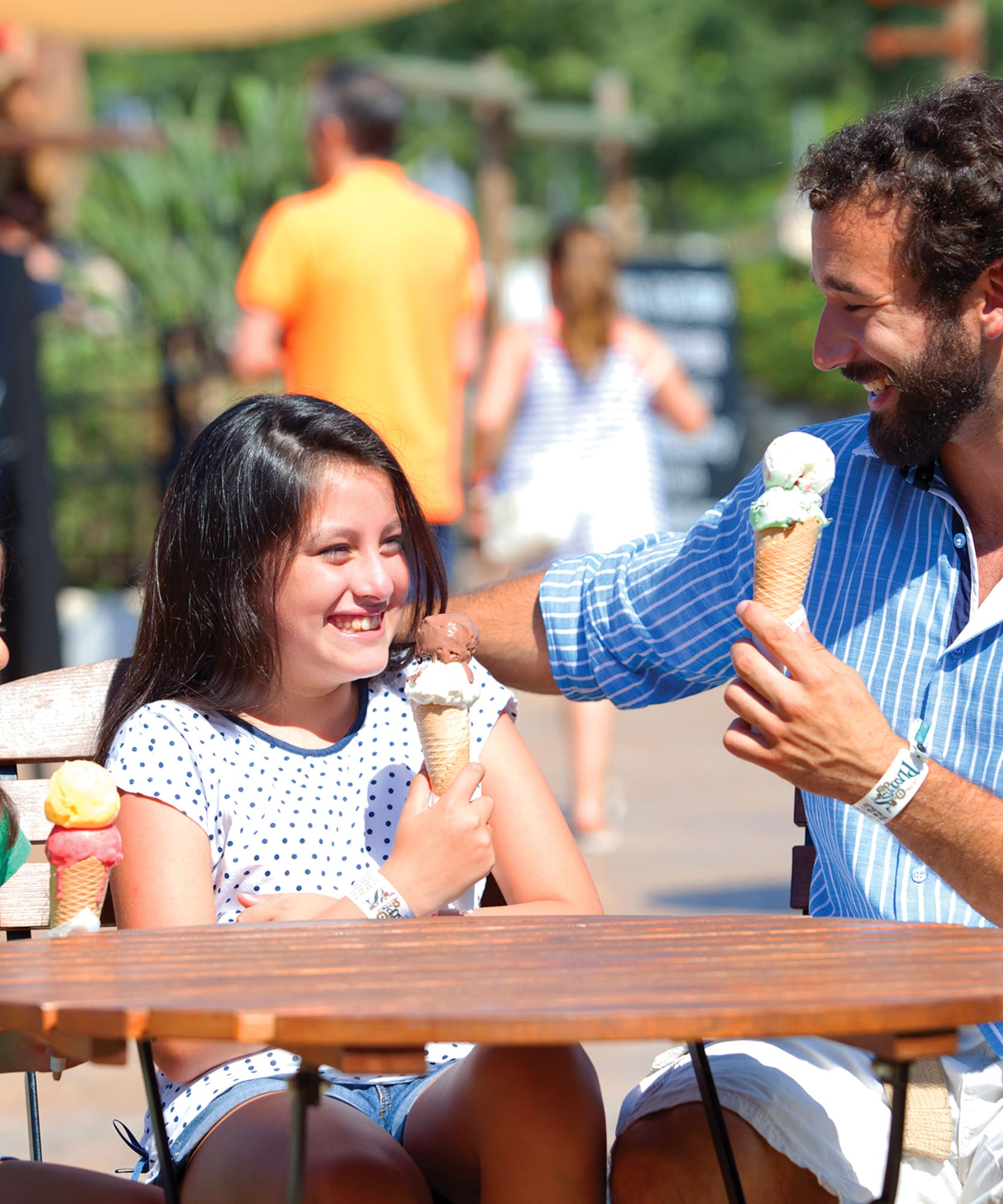 a man and two girls eating ice cream