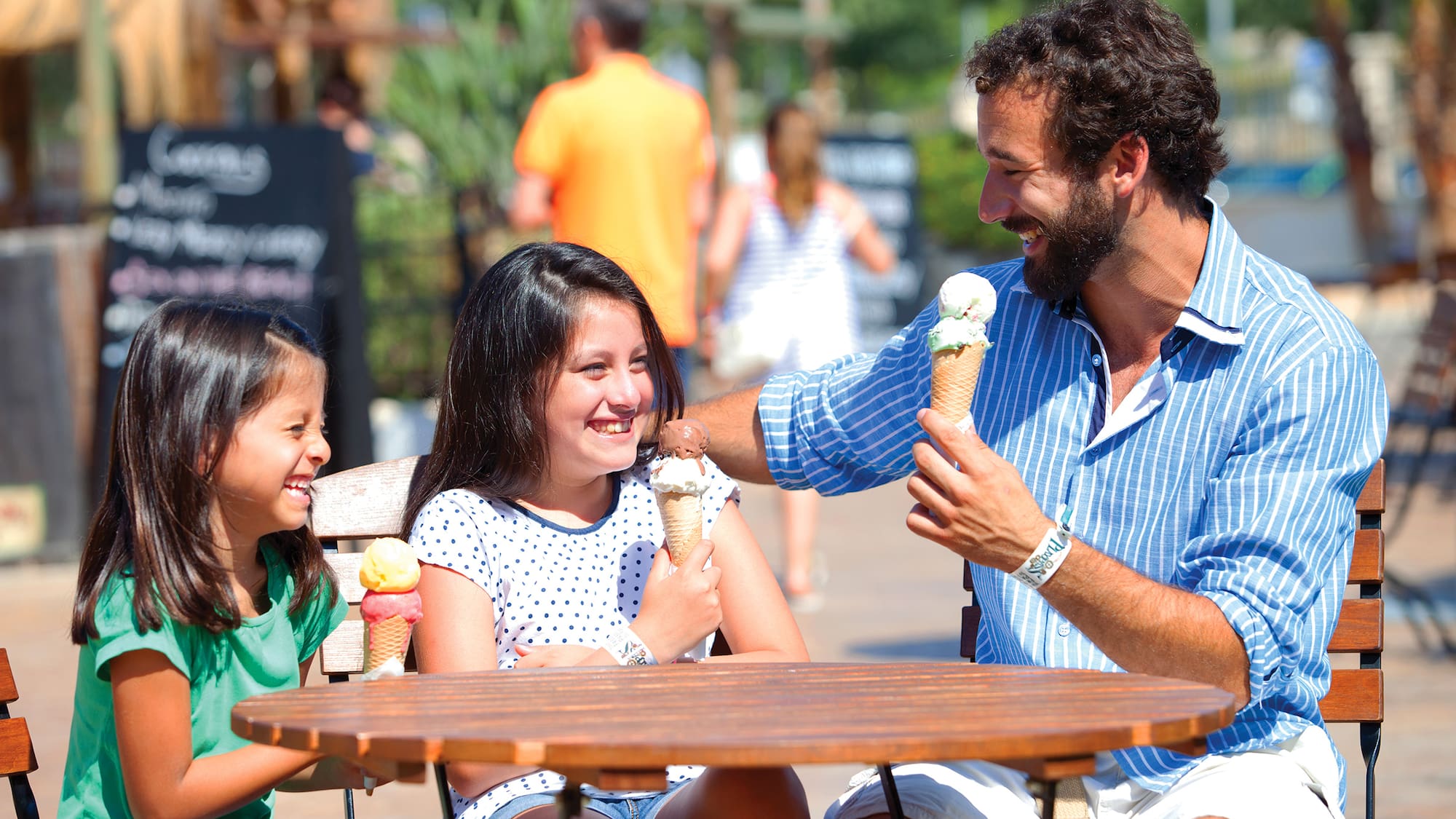 a man and two girls eating ice cream