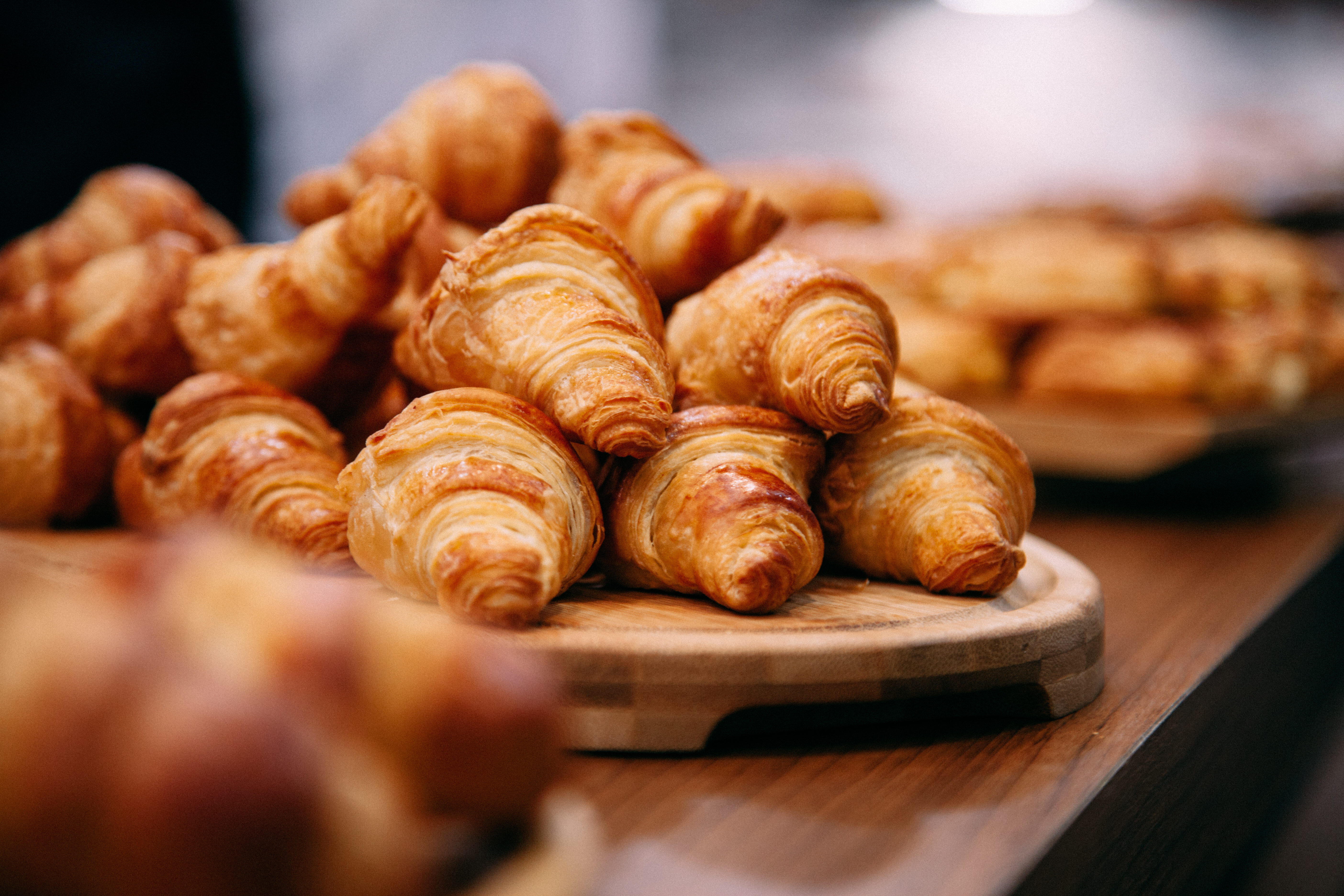 a group of croissants on a wooden plate