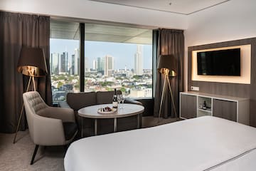 a room with a bed and a table and a television