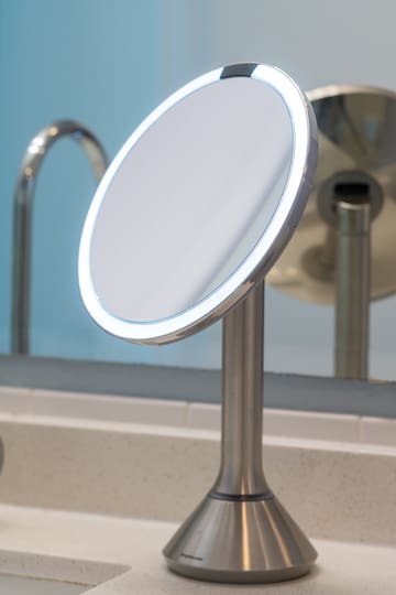 a round mirror on a stand