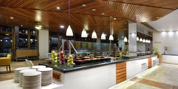 a buffet line with plates and fruit