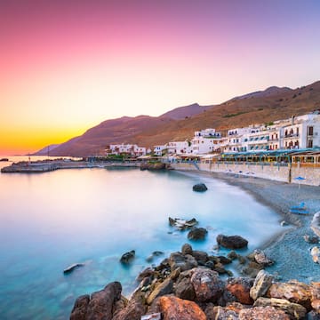 a beach with buildings and rocks