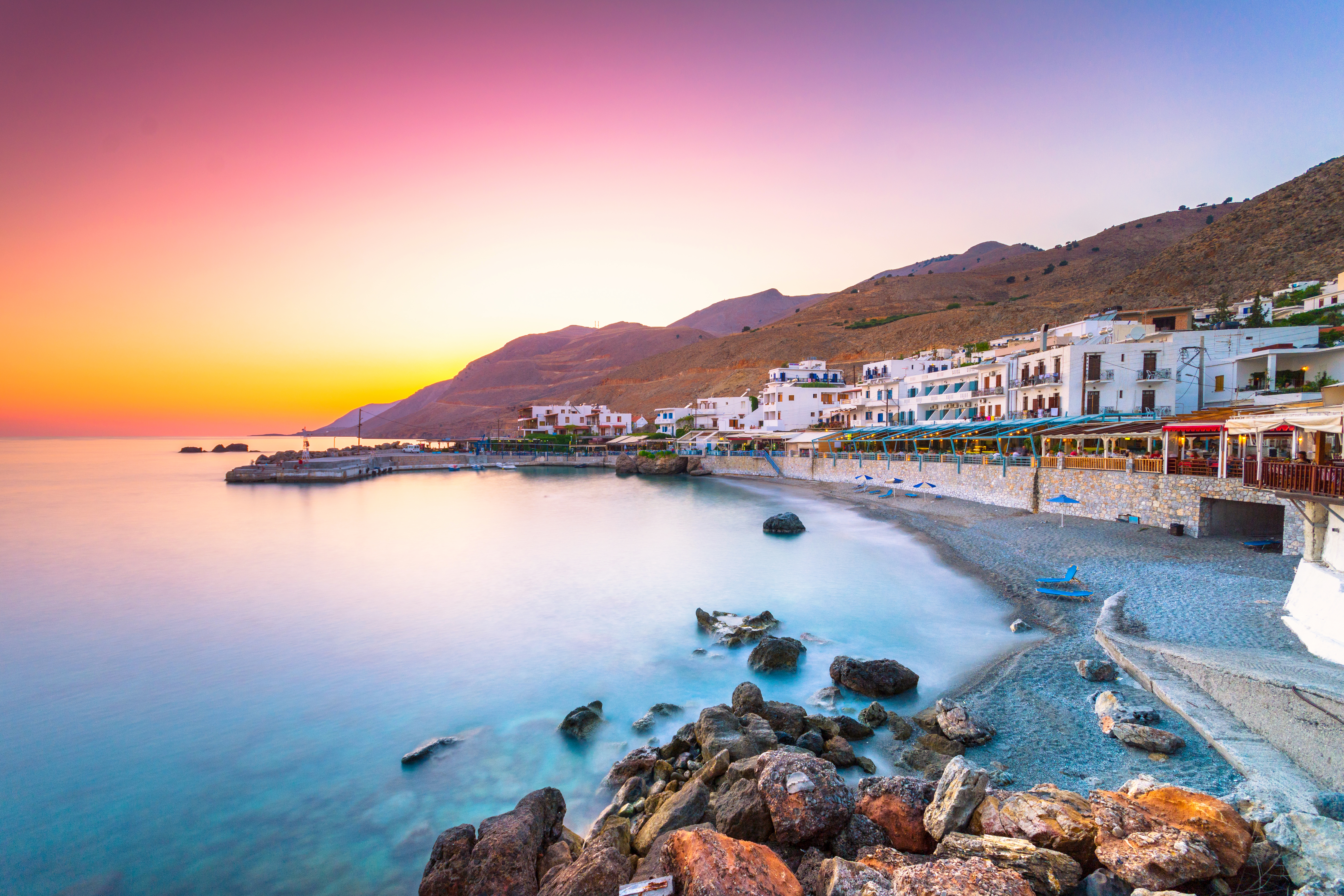 a beach with buildings and rocks