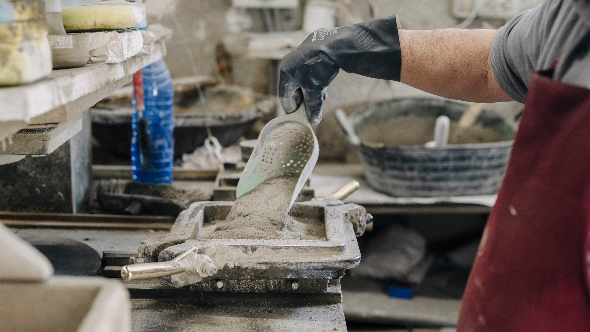 a person holding a scoop of cement